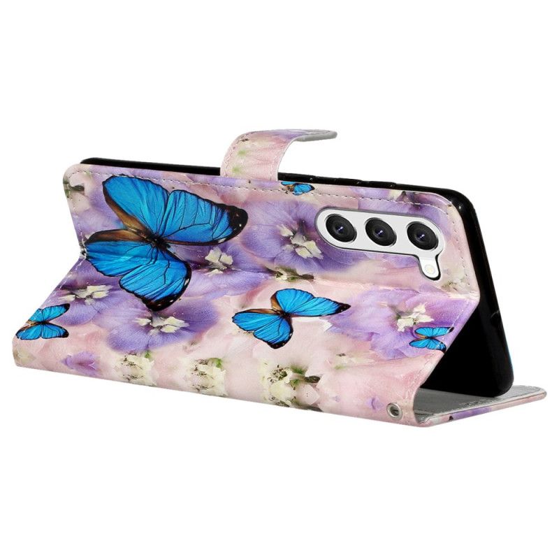 Housse Samsung Galaxy S24 Plus 5G Papillons Bleus et Fleurs Violettes à Lanière